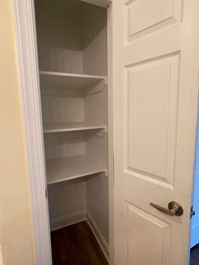 Youngsville apartment for rent - A white door with a handle is open to a pantry with empty shelves.