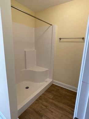 Youngsville apartment for rent - A white bathtub with a shower head and a white door.