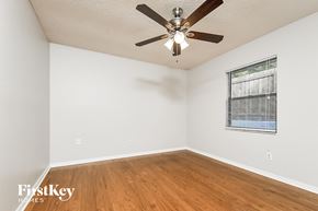 Valrico house for rent - a bedroom with a ceiling fan and wood floors