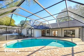 Valrico house for rent - a pool is under a glass roof in a house with a swimming pool