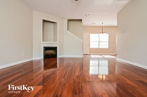 Locust Grove house for rent - A spacious room with wooden floors and a fireplace.