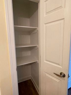 Youngsville apartment for rent - A white door with a handle is open to a pantry with empty shelves.