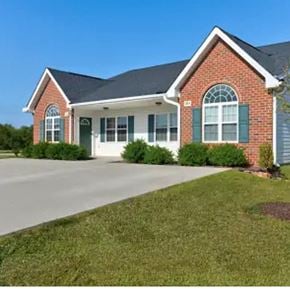 Youngsville apartment for rent - A red brick house with green shutters and a white garage door.
