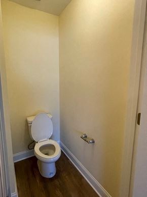Youngsville apartment for rent - A white toilet in a small room with a door on the right.