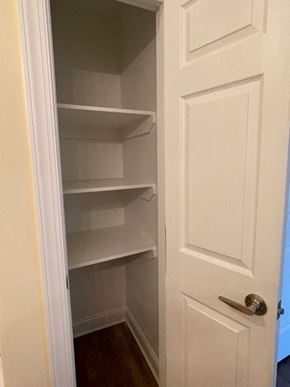 Youngsville apartment for rent - A white door with a handle is open to a pantry with empty shelves.