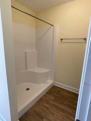 Youngsville apartment for rent - A white bathtub with a shower head and a white door.