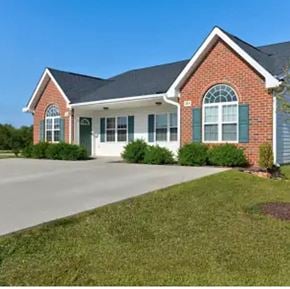 Youngsville apartment for rent - A red brick house with green shutters and a white garage door.