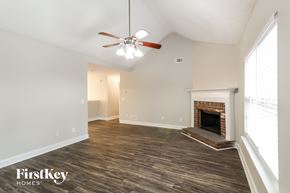 Loganville house for rent - A spacious room with a fireplace and a ceiling fan.