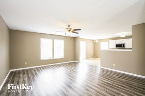 Noblesville house for rent - an empty living room with a ceiling fan and a kitchen