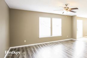 Noblesville house for rent - an empty living room with a ceiling fan and a window