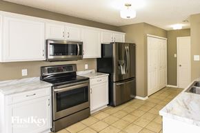 Noblesville house for rent - a kitchen with stainless steel appliances and white cabinets