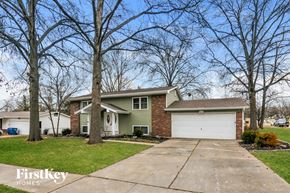 Maryland Heights house for rent - A house with a garage is surrounded by bare trees.