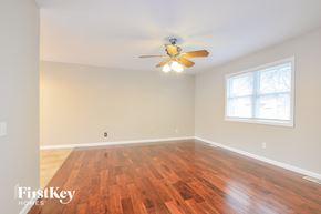 Maryland Heights house for rent - A room with wooden floors and a ceiling fan.