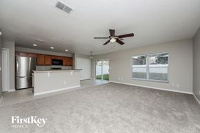 Winter Garden house for rent - A spacious living room with a ceiling fan and a kitchen area in the background.