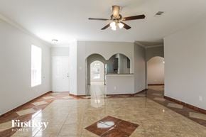 Spring house for rent - A spacious room with a ceiling fan and a rug on the floor.