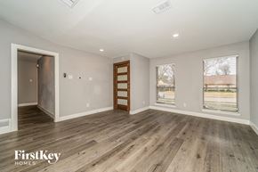 Carrollton house for rent - A spacious room with wooden flooring and a view of a highway outside the window.