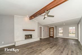 Carrollton house for rent - A spacious room with a fireplace and wooden floors.