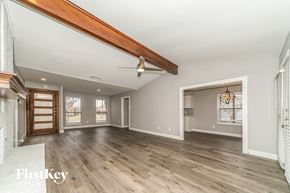Carrollton house for rent - A spacious room with wooden floors and a large window.