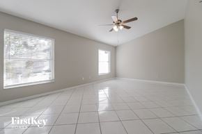 Orlando house for rent - A spacious room with a ceiling fan and a window with blinds.