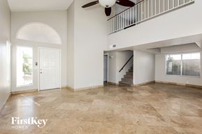 Glendale house for rent - A spacious room with a staircase and a ceiling fan.