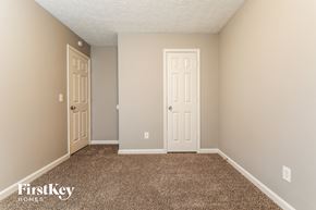 Duluth house for rent - a bedroom with a carpeted floor and two doors