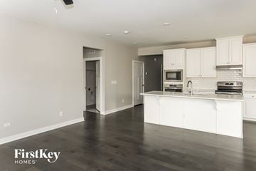 Mint Hill house for rent - A kitchen with white cabinets and a wooden floor.