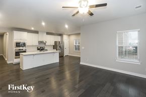 Mint Hill house for rent - A spacious kitchen and living room with a wood floor and a ceiling fan.