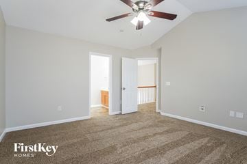 Jamestown house for rent - a living room with carpet and a ceiling fan