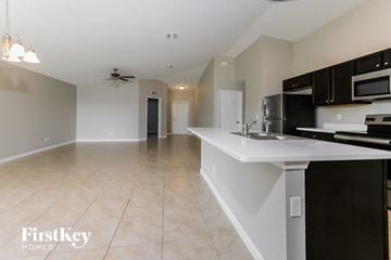 Port St. Lucie house for rent - A kitchen with a white countertop and black cabinets.