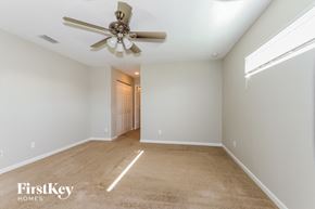 Port St. Lucie house for rent - A spacious room with a ceiling fan and a carpeted floor.