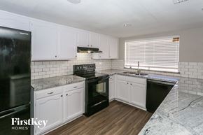 Glendale house for rent - a white kitchen with black appliances and white cabinets