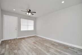 Houston apartment for rent - A room with a ceiling fan and a door.