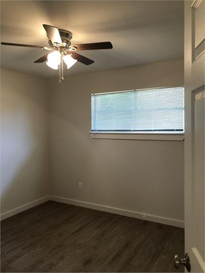 Houston apartment for rent - A room with a ceiling fan and a window with blinds.