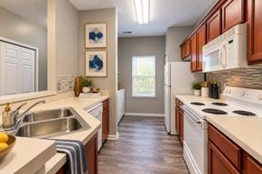 Wayne townhouse for rent - A kitchen with a white fridge and stove top oven.