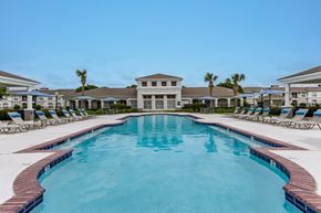 Lafayette apartment for rent - a large swimming pool with chairs around it in front of a house