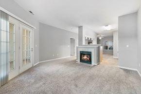 Portage apartment for rent - A living room with a fireplace and grey carpet.