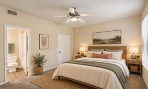 Cedar Hill townhouse for rent - A bedroom with a large bed and a ceiling fan.