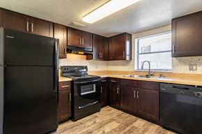 Clearwater apartment for rent - a kitchen with black appliances and wooden cabinets