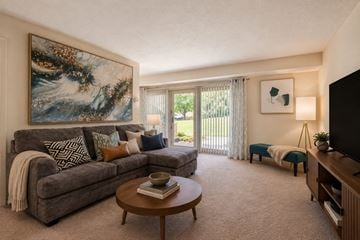 Owings Mills townhouse for rent - A living room with a grey couch, a coffee table, and a painting on the wall.