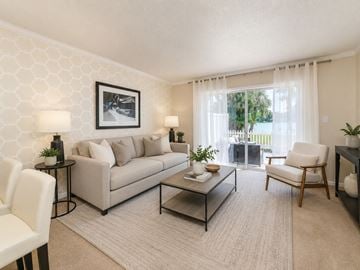 Tampa townhouse for rent - A living room with a grey couch, a coffee table, and a painting on the wall.
