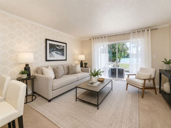 Tampa townhouse for rent - A living room with a grey couch, a coffee table, and a painting on the wall.