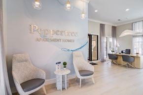 Lafayette apartment for rent - A modern living room with a Peppertree Apartment Homes sign on the wall.