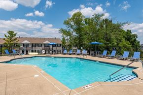 Miamisburg apartment for rent - our resort style swimming pool is next to our building with blue chairs and trees