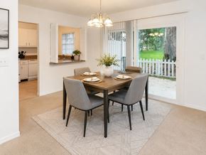 St. Petersburg townhouse for rent - A dining room with a table set for two and a view of a white picket fence and greenery outside the window.
