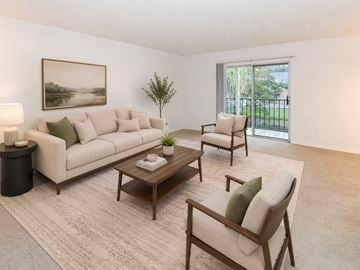 St. Petersburg townhouse for rent - A living room with a white couch, a wooden coffee table, and a painting on the wall.