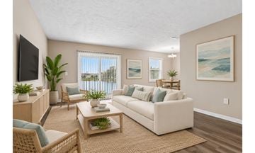 St. Petersburg townhouse for rent - A living room with a white couch, a wooden coffee table, and a painting on the wall.