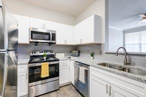 Shreveport apartment for rent - a kitchen with stainless steel appliances and white cabinets