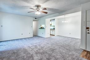 Concord apartment for rent - A spacious room with a ceiling fan and carpeted floor.