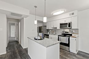 Olney apartment for rent - a kitchen with white cabinets and stainless steel appliances