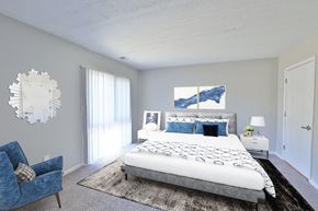 Cockeysville apartment for rent - a bedroom with a bed and a blue chair